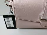 pink purse with a tag attached to it sitting on a table