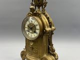 a gold clock sitting on top of a white table