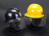 pair of yellow and black hard hats with face shields on a black background