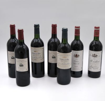 six bottles of wine are lined up in a row on a white surface