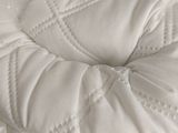 a close up of a bed with a white comforter on it