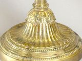 a gold candle holder with a candle on top of it