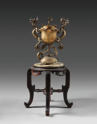 une image d'un vase en bronze posé sur une table en bois
