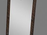 an ornately carved mirror on a grey background