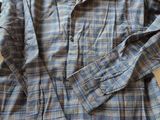 an image of a blue and grey plaid shirt sitting on top of a bed