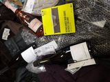 a pile of clothes and bottles of wine on a bed