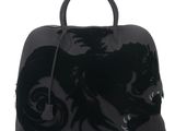 a close up of a black handbag with a dragon on it