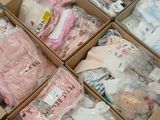 many boxes of baby clothes sitting on a table