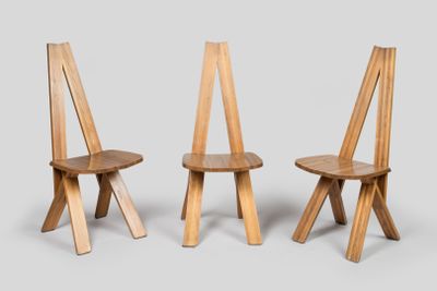 trois chaises en bois, dont l'une est placée de l'autre côté de la chaise