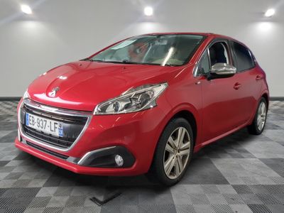 une voiture rouge est garée dans une pièce au sol en damier