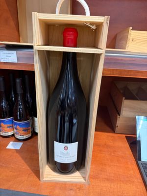 une bouteille de vin dans un coffret en bois sur une table