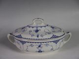 a blue and white bowl with a lid on a white table