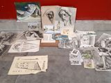 many drawings and pictures on the floor next to a red wall