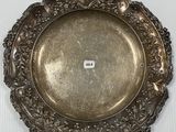 une assiette en argent posée sur une table blanche, sur laquelle figure un numéro