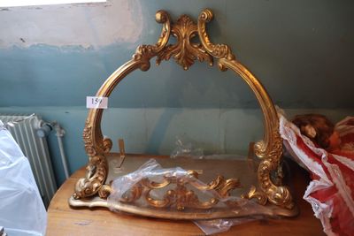 un miroir doré posé sur une table en bois dans une pièce