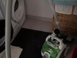 un aspirateur posé par terre à côté d'une machine à laver
