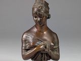 a bronze statue of a woman with a hat on her head