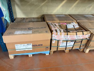 many boxes that are stacked on pallets on the floor