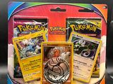 three pokemon cards in a display case on a table
