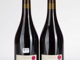 deux bouteilles de vin rouge posées l'une à côté de l'autre sur une surface blanche