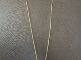 a gold necklace with two interlocked circles on a chain