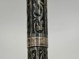 un vieux stylo en argent orné d'un motif en noir et blanc