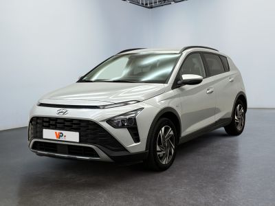 Une voiture blanche est garée dans une pièce équipée d'un ventilateur de plafond