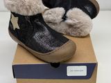 baby ' s black and white boots with fur lined up on top of a cardboard box