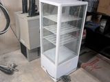 a white refrigerator sitting next to a bike in a garage