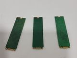 three pieces of green plastic with gold trims on a white surface