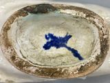 a close up of a bowl with a blue flower on it