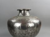 a silver vase that is sitting on a table