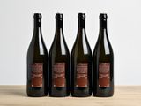 trois bouteilles de vin posées sur une table en bois