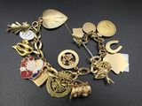un bracelet en or orné de nombreuses breloques, posé sur une table
