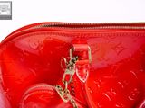 a red purse with a gold chain hanging from it