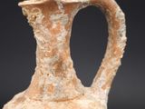 a small vase with a handle on a black background