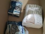 two bags of cat food in a box on the floor