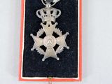 a silver medal with a crown on top of it