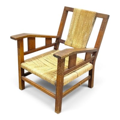 an image of a wooden chair with a wicker seat and arm rest