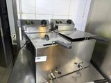 two deep fryers sitting on a counter in a kitchen