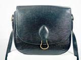 un sac à main noir posé sur une boîte blanche