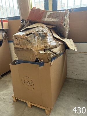 une boîte remplie de carton posée sur une palette devant une fenêtre