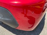 a close up of a red car ' s bumper with a sticker on it