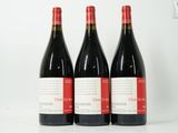 trois bouteilles de vin rouge posées côte à côte sur une table