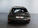 the back of a grey car in a room with a white wall