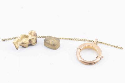 two pieces of jewelry that are on a chain