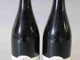 deux bouteilles de vin rouge posées l'une à côté de l'autre sur une table