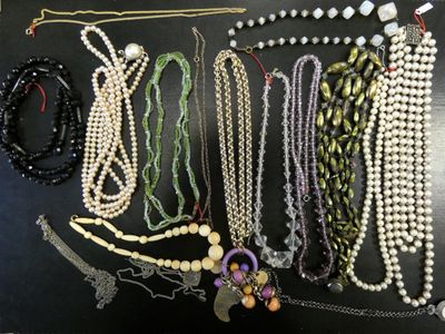 several necklaces and bracelets are arranged on a black surface