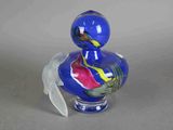 un canard en verre bleu orné d'un motif rouge et jaune sur le corps