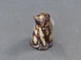 une petite figurine représentant un chat assis sur une table